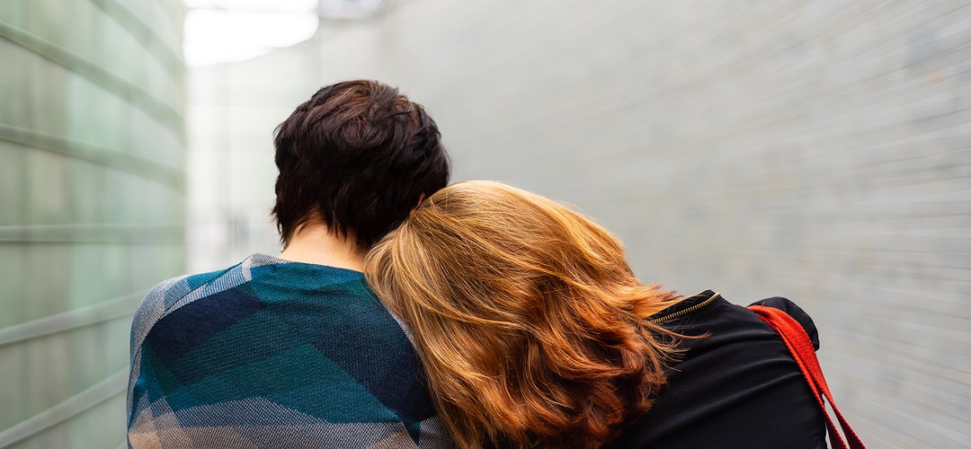 Une femme a la tête posée sur l'épaule d'une personne